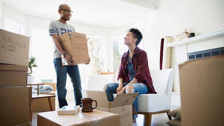 Couple packing up moving boxes